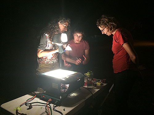 projecting scaled drawings of mural images onto large paper taped to the N Street Park mural to create mural stencils