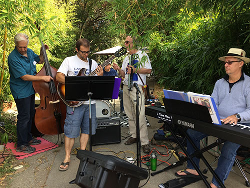 a talented band entertains street mural volunteers