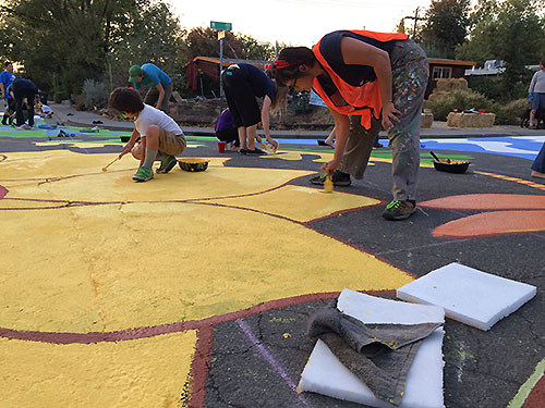 Danielle Fodor adds another coat of yellow paint to the sunflower.