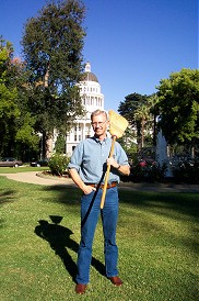 John Munn with broom in front of state capitol building.